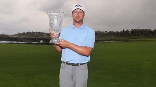 Brice Garnett holding the Corales Puntacana Championship trophy