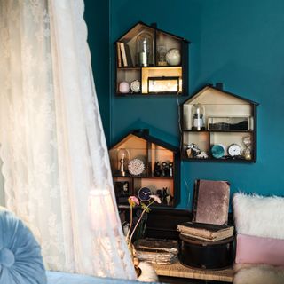 blue wall with wooden shelves and white curtain