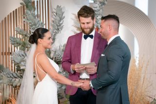 Bronte Schofield (left) and Harrison Boon (right) holding hands at the altar