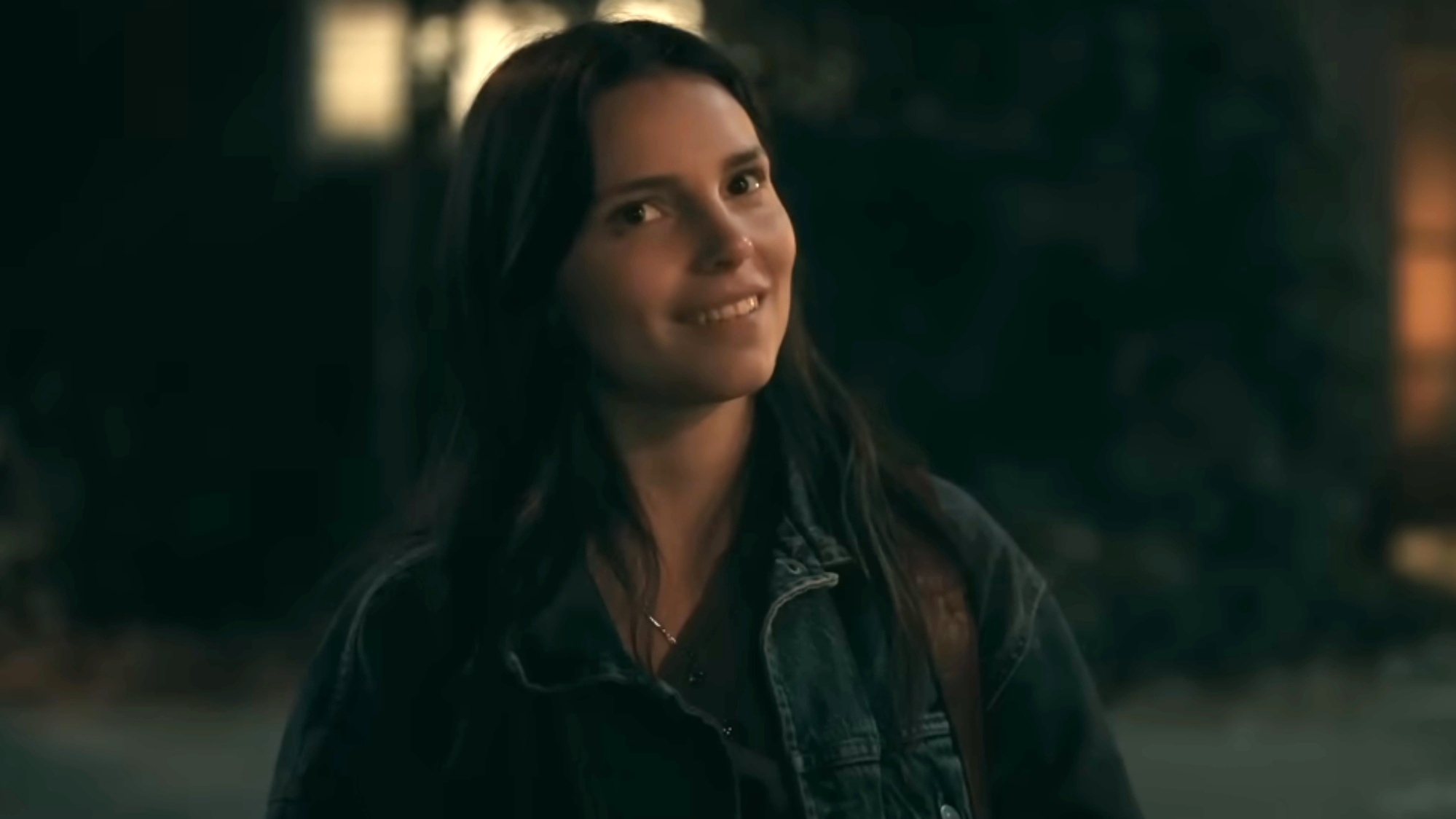 A screenshot of Inde Navarrette as Nikki looking at the camera with a smile in Obsession.