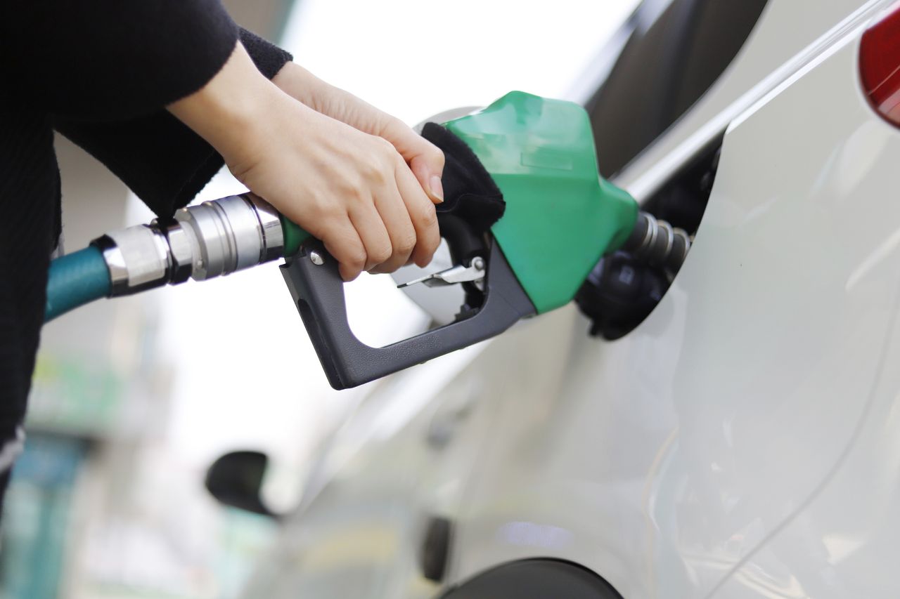 Save money on fuel and improve your car&#039;s fuel efficiency - Cropped Hand Of Woman Refueling Car