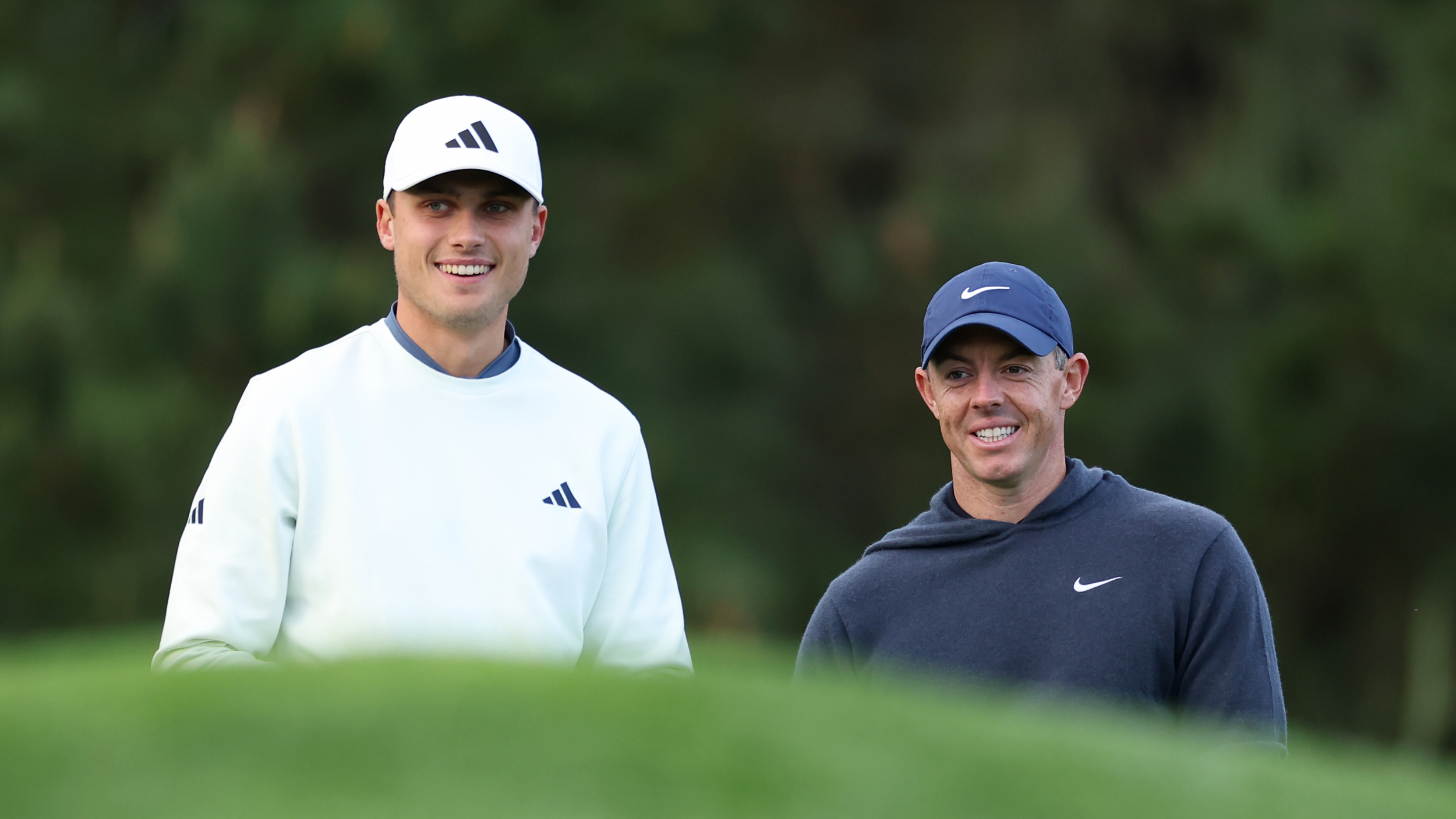 Ludvig Aberg and Rory McIlroy smile while stood next to each other at the 2024 AT&amp;T Pebble Beach Pro-Am