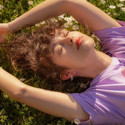 Best Retinol Body Lotions - Beautiful young lady enjoying the sun in the park - getty images - 1499992339