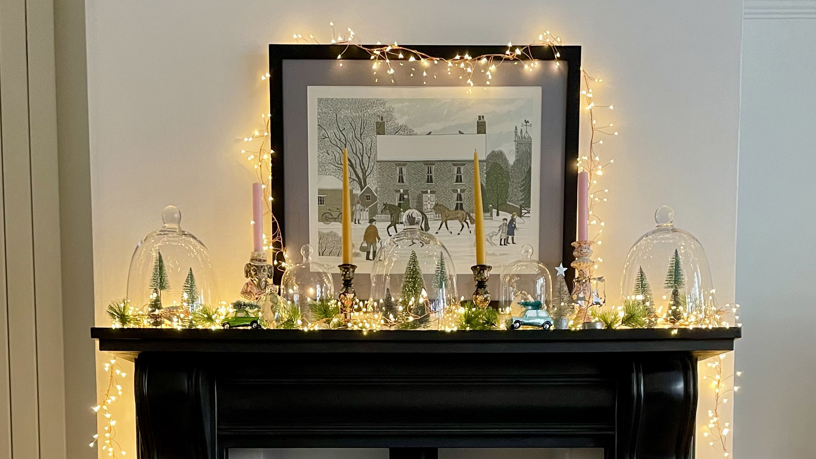 fireplace with candles and lights on top of the mantle