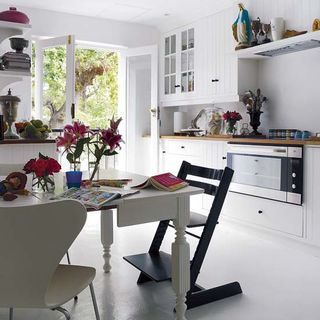 kitchen area with white cabinets and dining table and chair