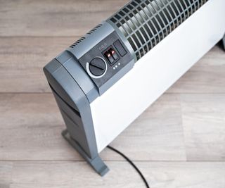 An electric heater on a light wood floor