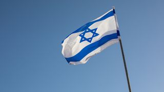 An Israeli flag against a blue sky