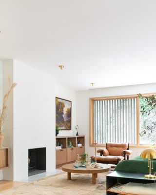 a contemporary living room with a circular coffee table and green couch and brown accent chair