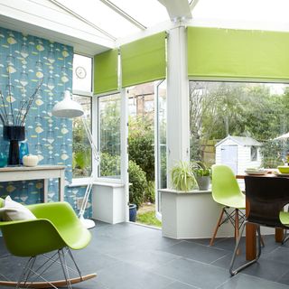 conservatory with statement wallpaper and green blinds