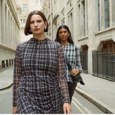 Two models walking down a street wearing plaid outfits sold at Simply Be