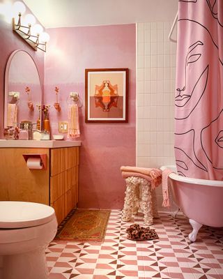 Pink modern bathroom with white patterned floor and ceiling tiling and artistic shower curtain