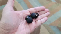 The Sony WF-1000XM4 wireless earbuds held in hand