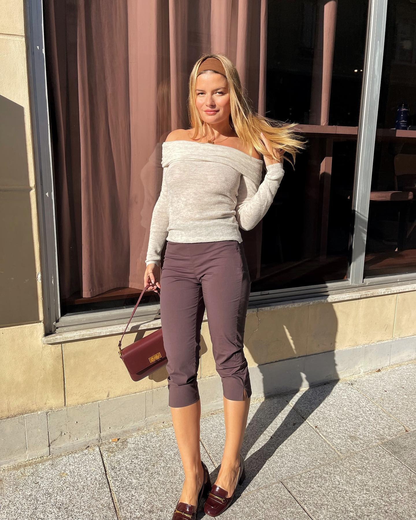 Influencer @sabinasocol wears capri pants with loafers and a light knit.