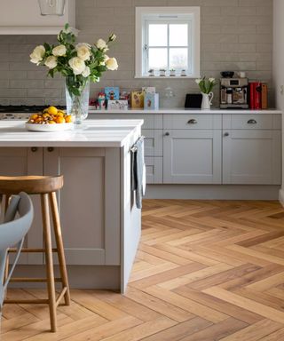 A classic light grey kitchen with wood flooring