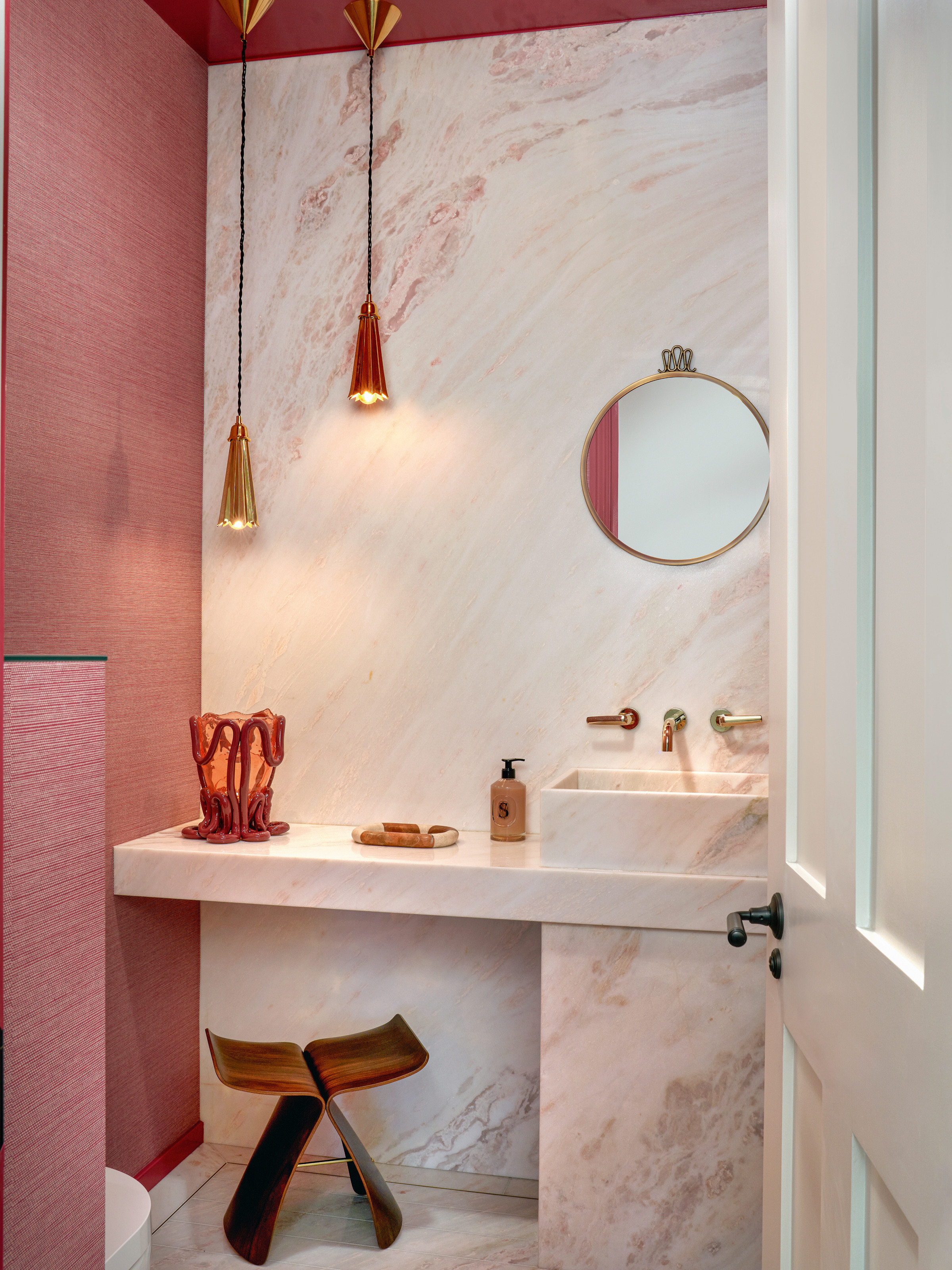 Bathroom with pink walls and white marble built-in vanity and sink