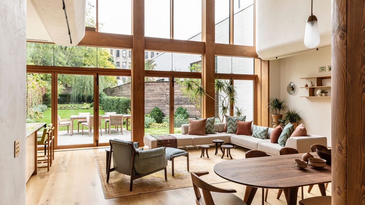 An open living space looks out through large windows onto a landscaped garden