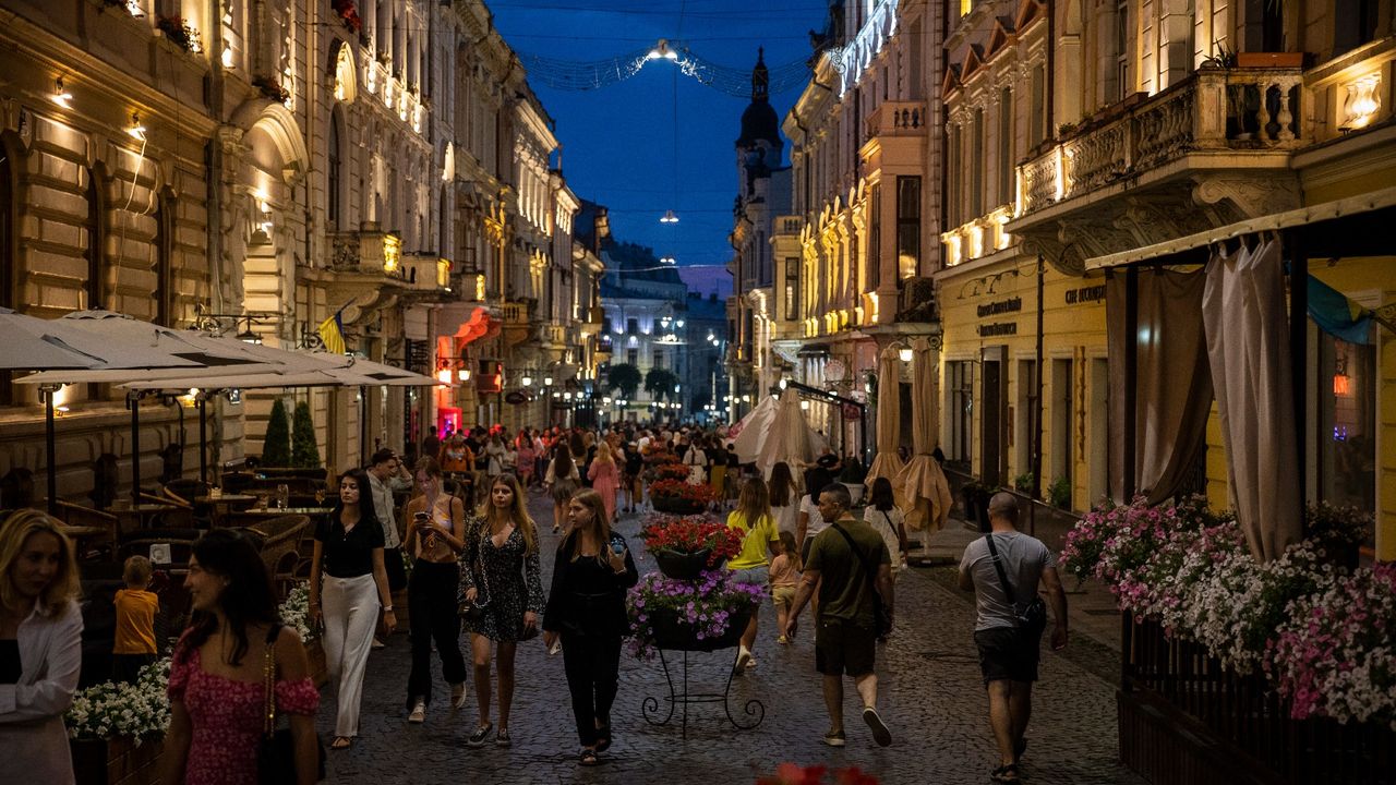 People enjoy a summer evening strolling down one of the main streets in Chernivtsi,