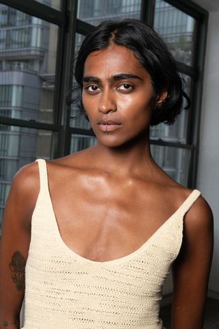 Model backstage at Nanushka wearing creamy skin, a key Spring/Summer 2025 Fashion Month beauty look