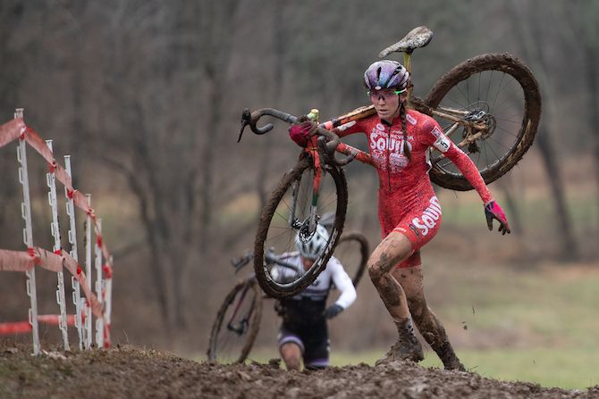 Samantha Runnels shoulders her bike on the muddy course