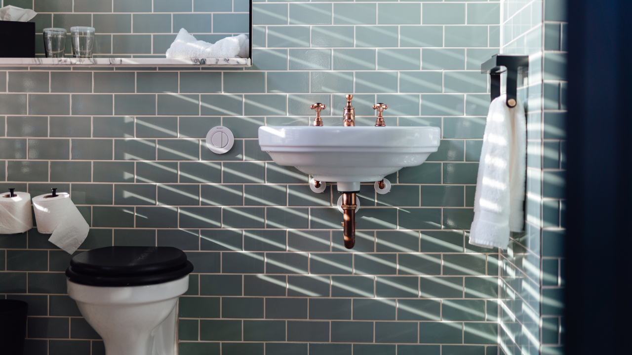 A tiled bathroom with a raised sink and toilet.