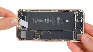 Adhesive strips being removed from the iPhone 8's battery. Credit: iFixit