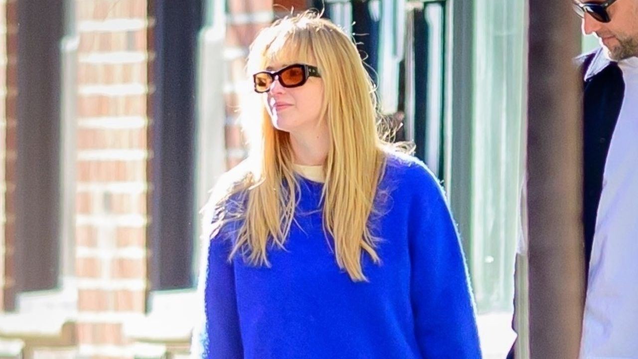 Jennifer Lawrence walking in new york city wearing a blue sweater and a doctor bag