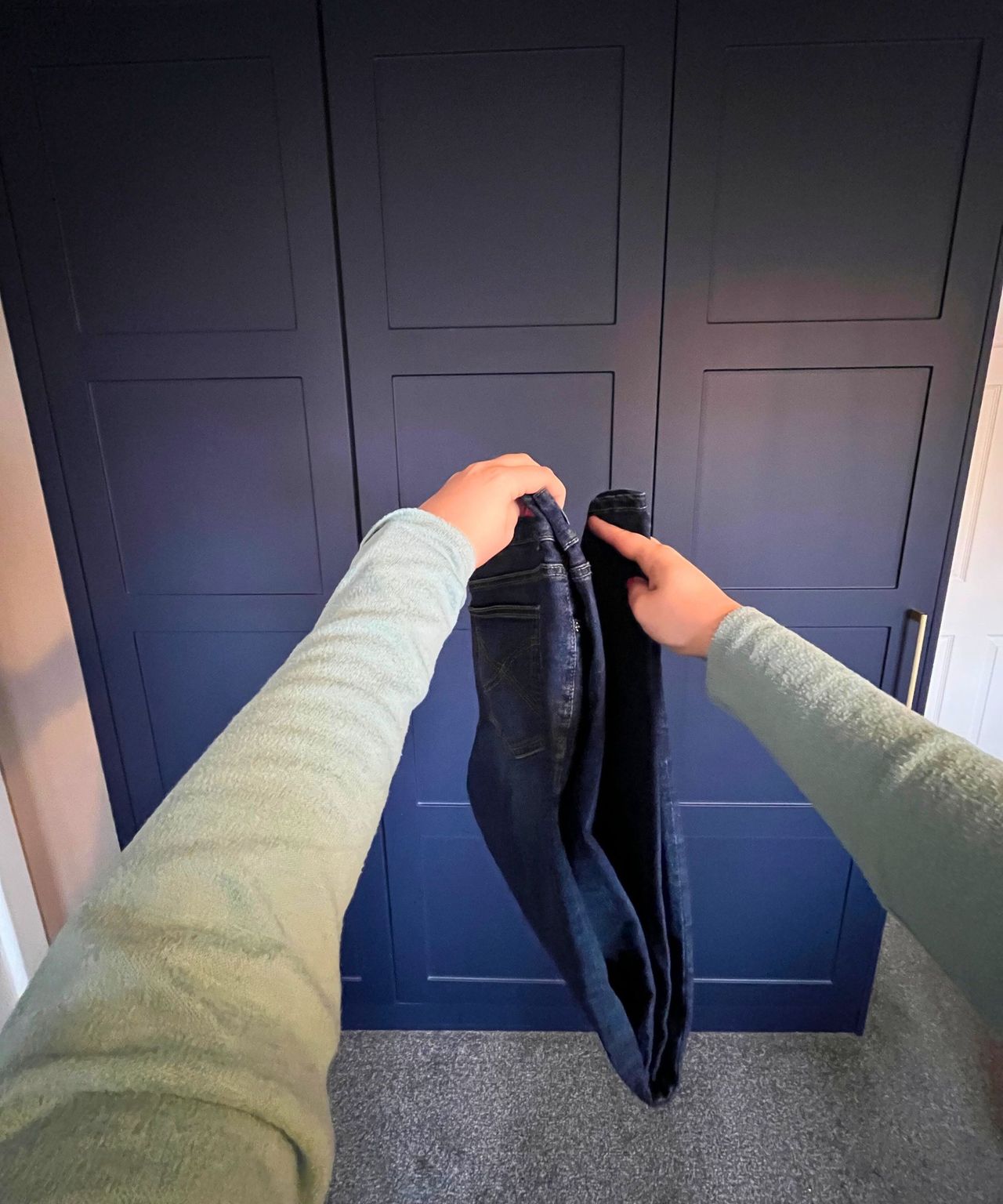 Pictured is the jeans sideways with the hems brought up together to touch the waistband