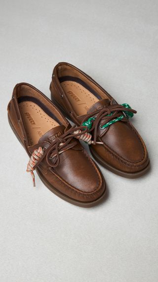 a pair of aritzia sperry shoes in front of a plain backdrop