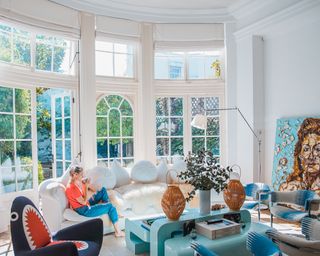 A woman on a sofa in a high-ceilinged living room