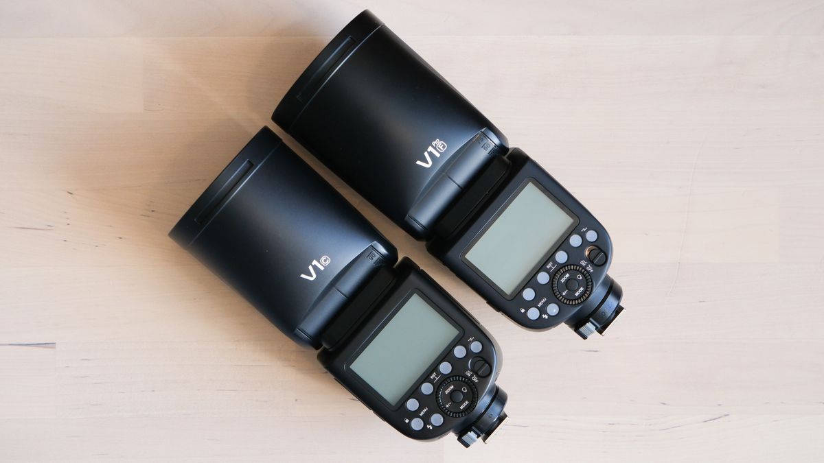 Godox V1Pro flashgun next to a Godox V1 flashgun on a wooden surface