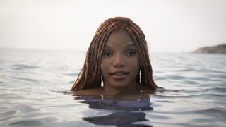 Halle Bailey as Ariel popping up out of the water in The Little Mermaid