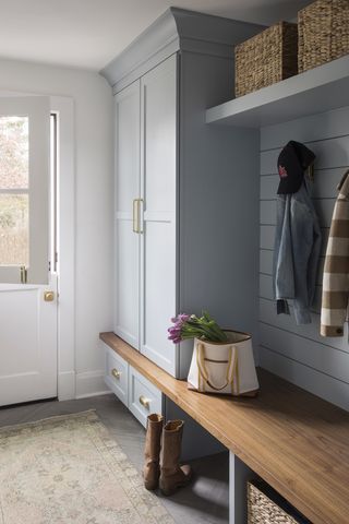 mudroom painted in light blue shade with timber bench