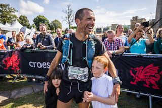 Russell Bentley is reunited with his children after the 2021 Montane Dragon's Back Race