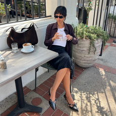 Stephanie Arant in a tank top and slip skirt with a brown suede bag.