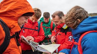 A group of hikers examine a map