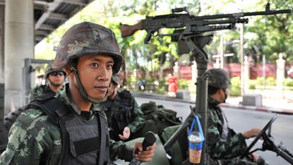 Thai army soldiers stand guard on a city centre street in Bangkok