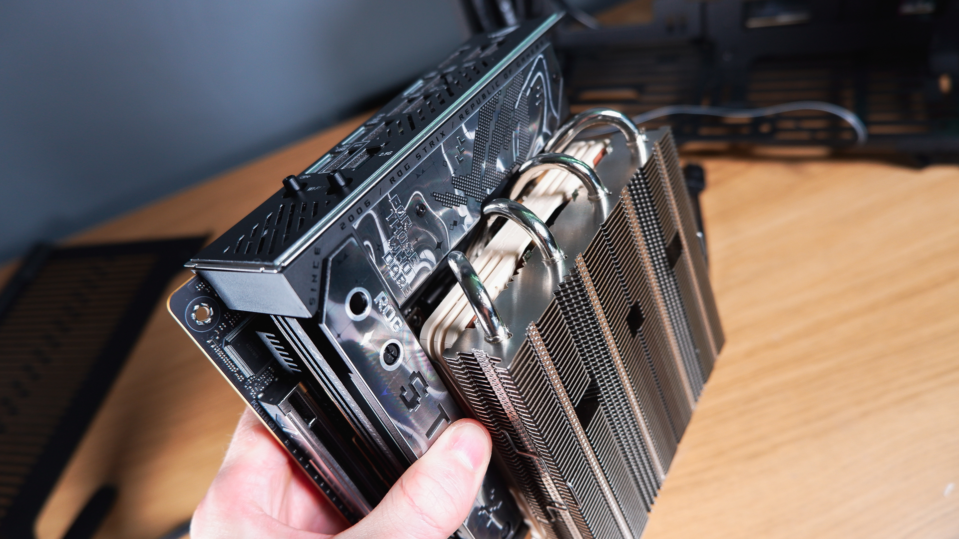 A compact gaming PC on a desk with various parts on show.