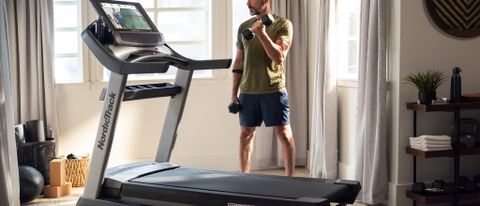 Man working out beside NordicTrack Commercial 2950 treadmill