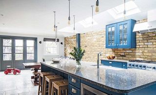 industrial style kitchen extension with blue shaker cabinets