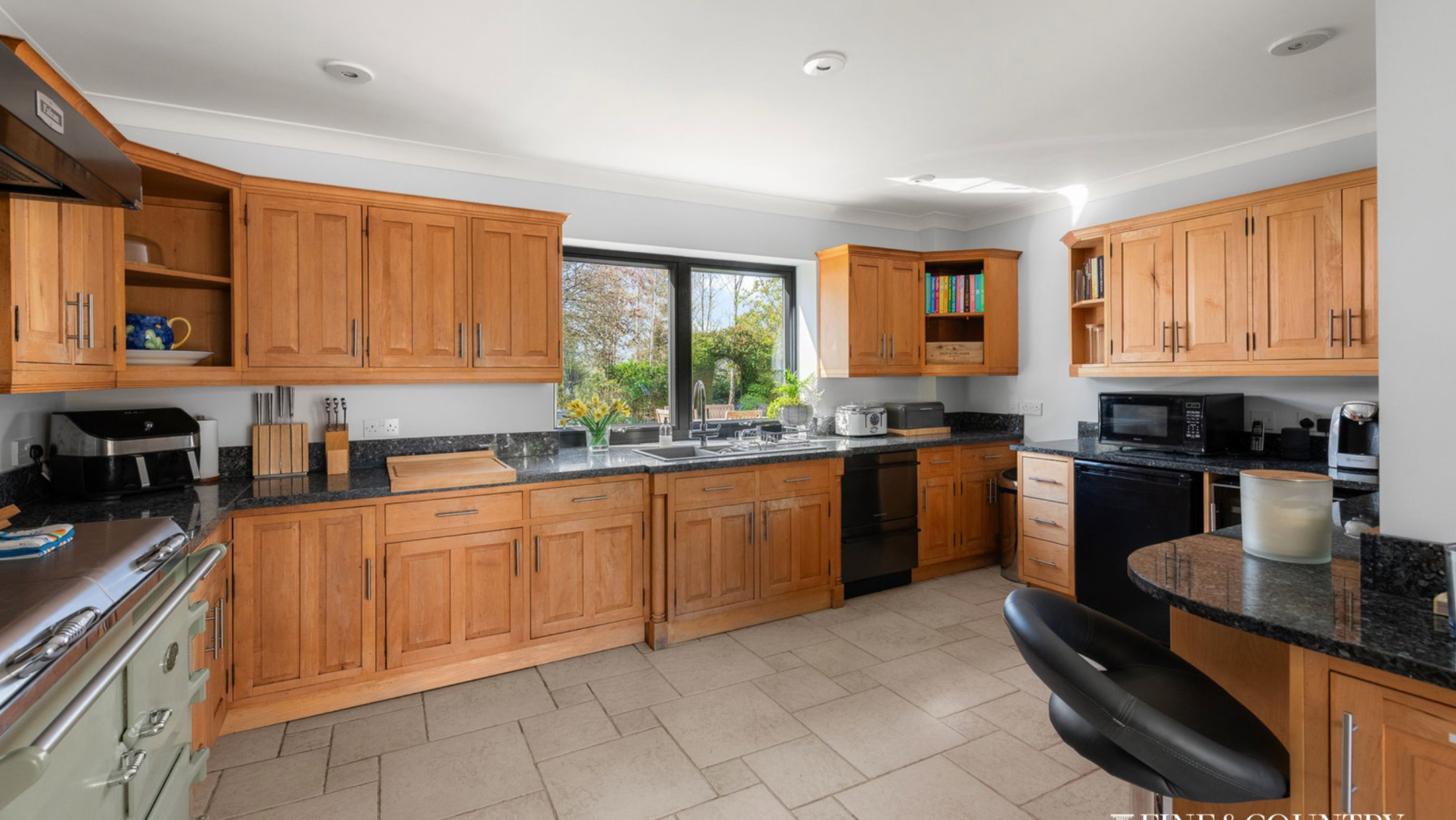 View of a kitchen with a stone floor and wooden cabinets
