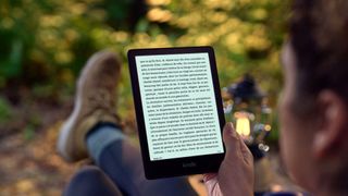 Kindle being read outside in a forest