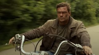 Alan Ritchson as Jack Reacher riding a motorcycle on Reacher