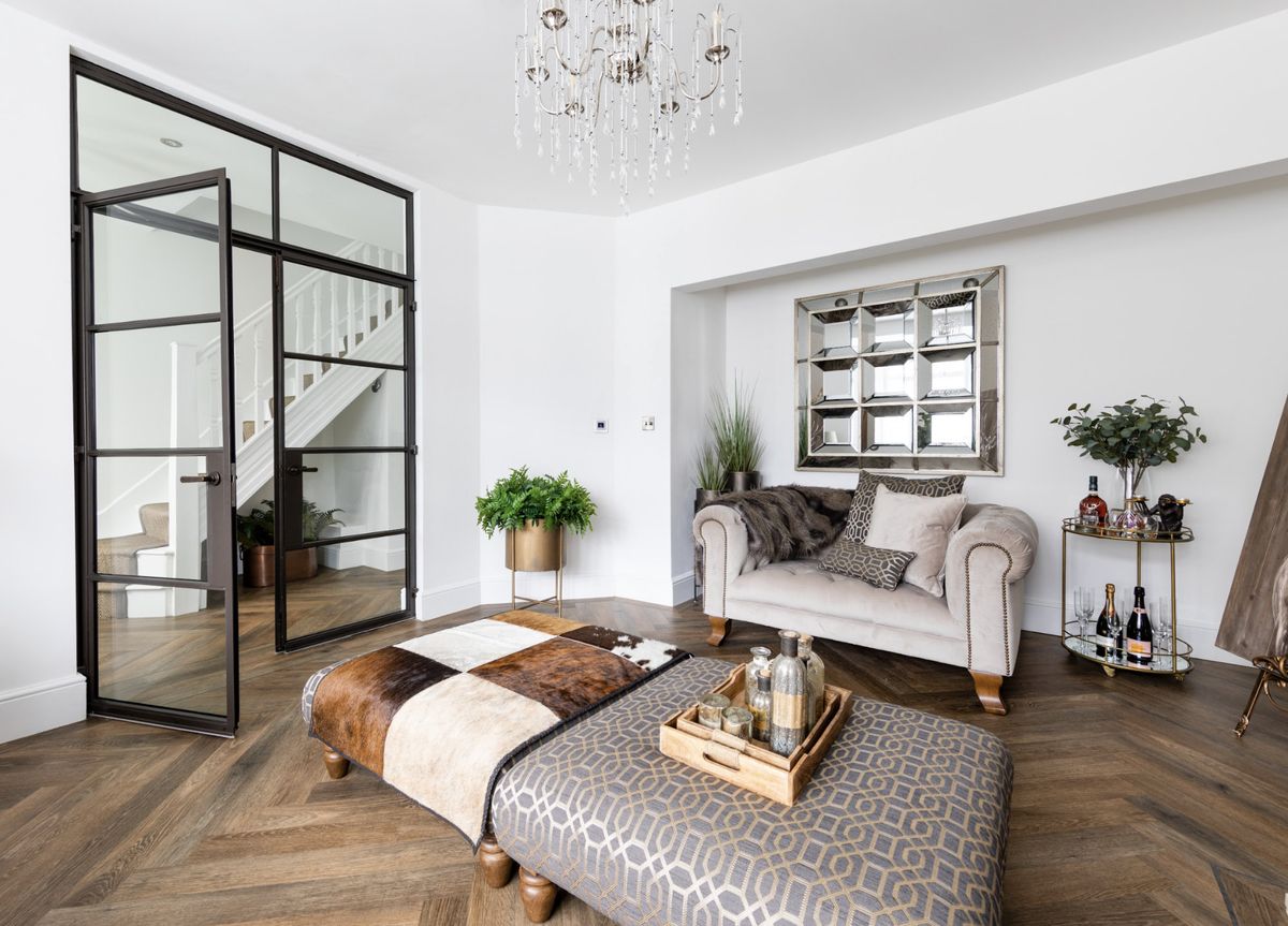 A contemporary living room entered through critall-style doors