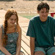 sadie soverall as percy and Matt Cornett as sam smiling and sitting on a dock together in every year after