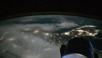 a lights from cities along the coast of a peninsula are seen at night from space