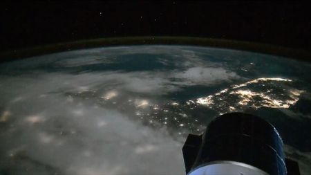 a lights from cities along the coast of a peninsula are seen at night from space