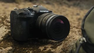 The OM System OM-1 camera on a rock