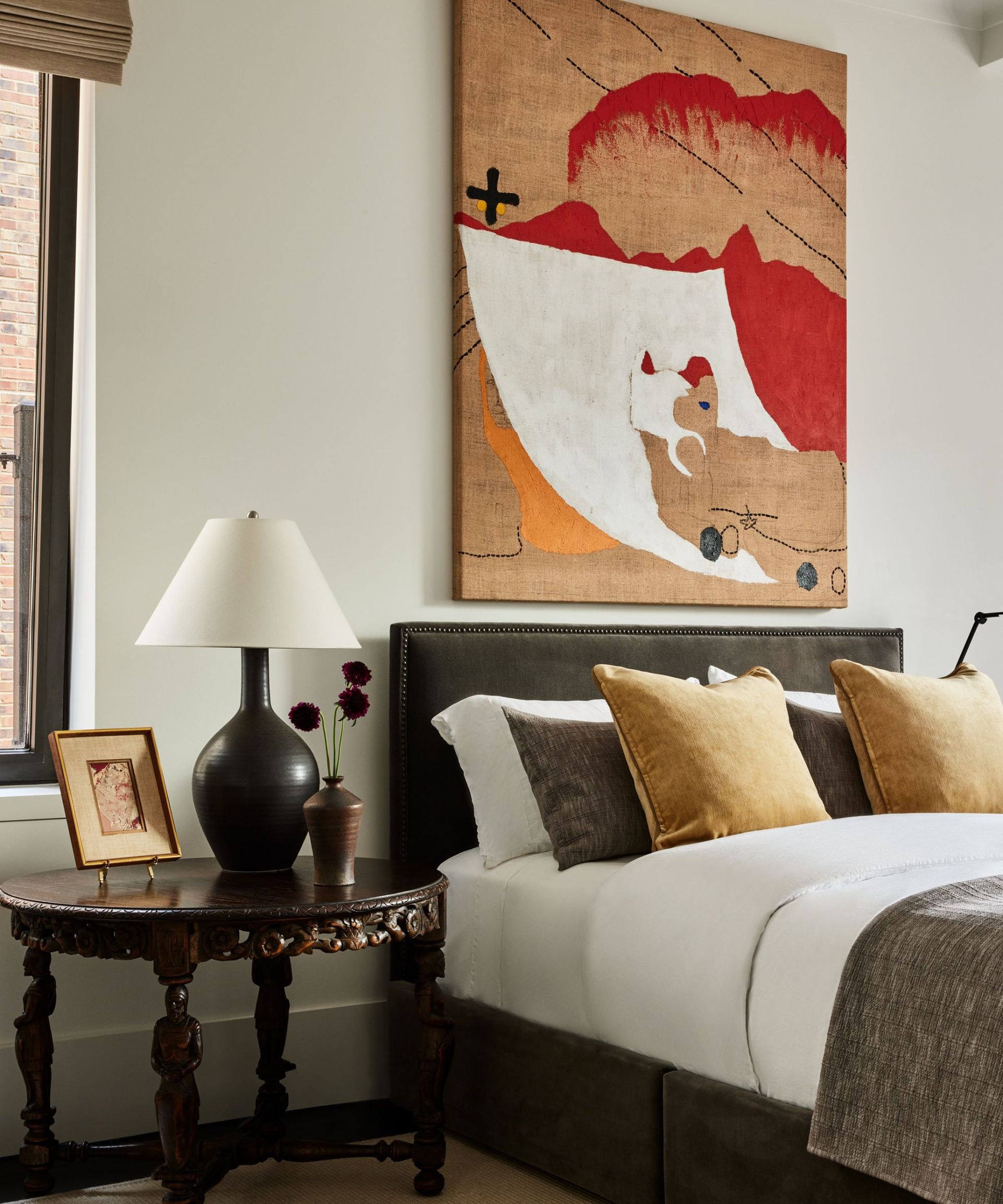 bedroom with colorful artwork at bedhead