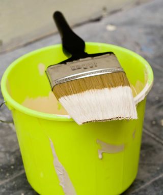 paint brush and bucket on paving