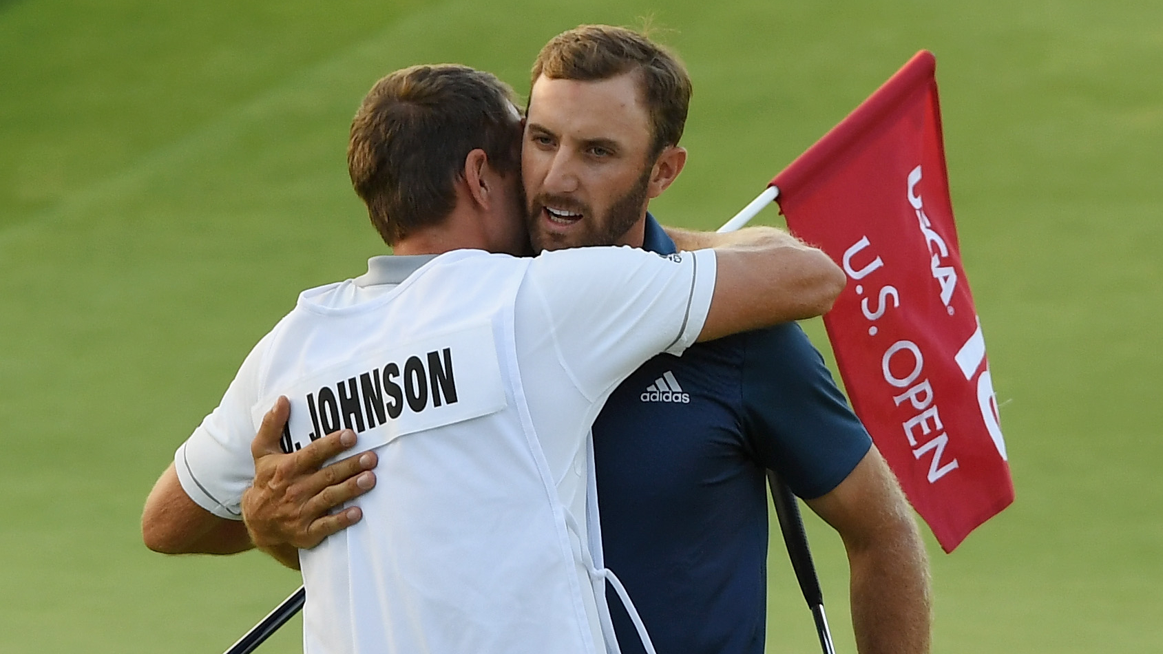 Dustin Johnson celebrates his US Open title with his caddie